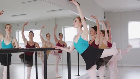 Kaukasische-Balletttänzerinnen-Trainieren-Zusammen-Mit-Einer-Barre-Vor-Einem-Spiegel-Während-Eines-Ballettunterrichts