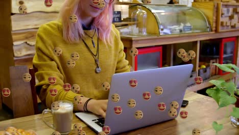 Emojis-moving-against-woman-using-laptop