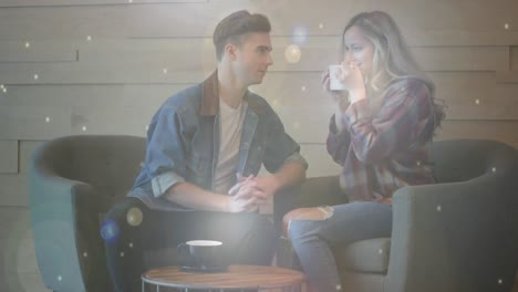 Glowing-spots-of-light-against-couple-talking-while-having-coffee