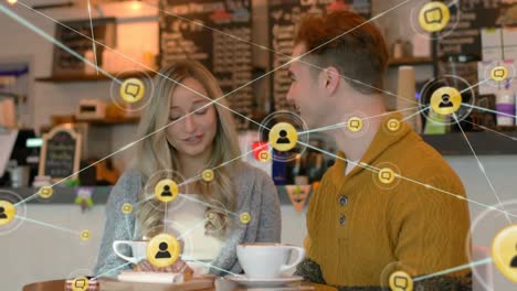 Animation-of-web-of-connections-over-Caucasian-couple-sitting-in-cafe-and-talking