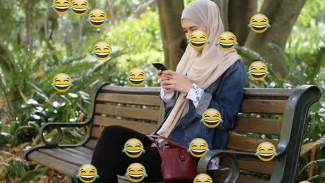 Emojis-moving-against-woman-in-hijab-using-smartphone