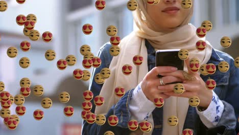Gesichtsemojis-Bewegen-Sich-Mit-Smartphone-Gegen-Eine-Frau-Im-Hijab