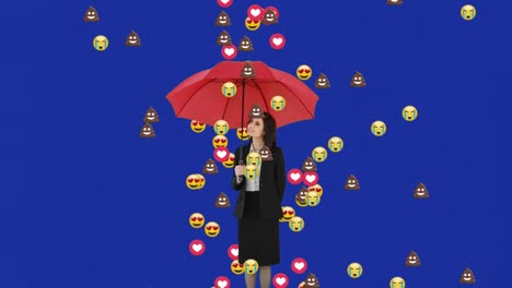 Emojis-Fallen-über-Eine-Geschäftsfrau,-Die-Einen-Regenschirm-Vor-Blauem-Hintergrund-Hält