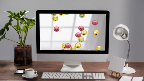 Emojis-moving-on-screen-of-computer-on-a-desk-