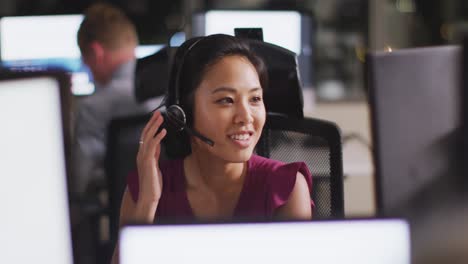 Professional-businesswoman-smiling-while-talking-on-phone-headset-in-modern-office-in-slow-motion
