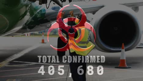 Digital-composite-video-of-hazard-sign-with-Total-Confirmed-number-rising-against-mid-airport-worker