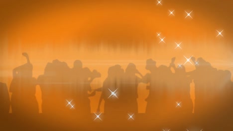 Digitally-generated-video-of-glowing-stars-and-silhouette-of-people-dancing-against-orange-backgroun