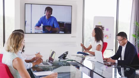 Professional-businesspeople-in-video-conference-clapping-together-in-meeting-room-in-modern-office-i
