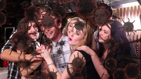 Digital-composite-video-of-Covid-19-cells-moving-against-group-of-friends-dancing-in-background