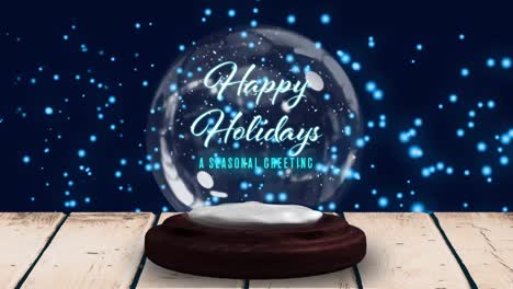 Happy-Holiday-text-in-snowball-against-blue-glowing-spots-in-background