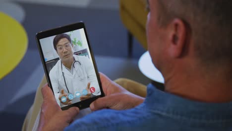 Älterer-Mann,-Der-Zu-Hause-Einen-Video-Chat-Auf-Seinem-Digitalen-Tablet-Führt