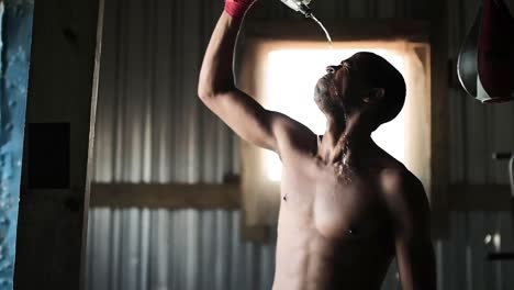 Boxer-pouring-water-on-his-face-in-the-gym