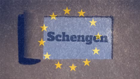 Yellow-stars-spinning-in-circles-against-Schengen-text-on-paper