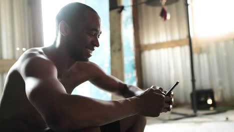 Boxeador-Usando-Teléfono-Inteligente-En-El-Gimnasio
