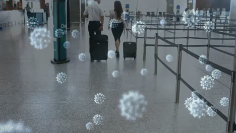 Animation-of-floating-Covid-19-cells-over-Caucasian-female-and-male-airport-workers-walking-at-airpo