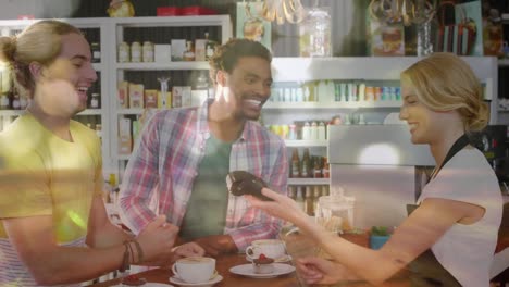 Animation-of-golden-light-circles-floating-over-mixed-race-same-sex-couple-paying-with-a-credit-card