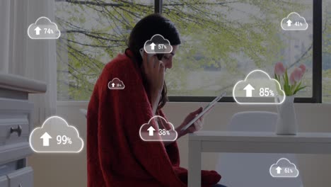 Multiple-cloud-icon-with-increasing-percentage-against-woman-talking-on-smartphone-while-using-digit