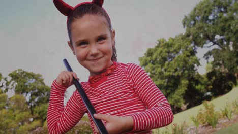 Girl-wearing-devil-costume-in-park-against-flickering-background