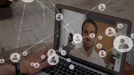 Digital-icons-with-network-of-connections-over-people-on-laptop.