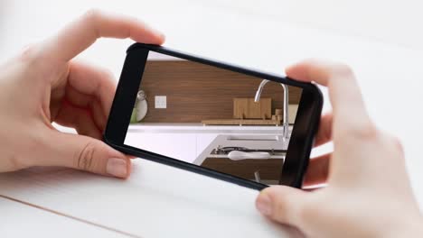 Person-Hält-Smartphone-Mit-Moderner-Kücheneinrichtung-Auf-Dem-Bildschirm