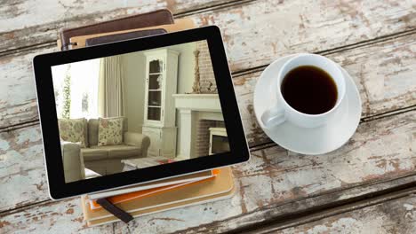 Digital-tablet-with-modern-living-room-interiors-displayed-on-screen-on-wooden-surface