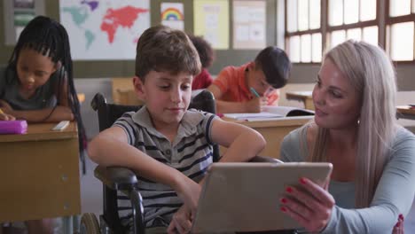 Lehrerin-Unterrichtet-Behinderten-Jungen,-Indem-Sie-In-Der-Schule-Ein-Digitales-Tablet-Verwendet