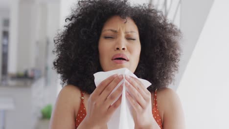 Woman-with-tissue-sneezing-at-home