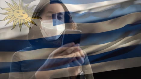 Greek-flag-waving-against-woman-wearing-face-mask-using-smartphone