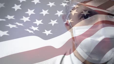 US-flag-waving-against-man-wearing-face-mask