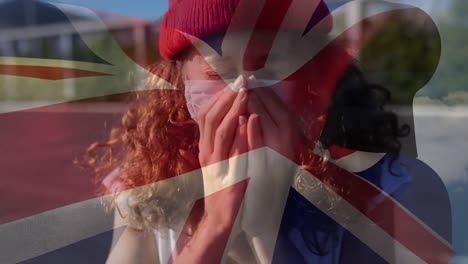 British-flag-waving-against-woman-wearing-face-mask-sneezing