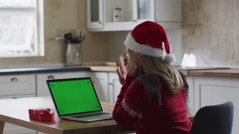 Frau-Mit-Weihnachtsmannmütze-Führt-Zu-Hause-Einen-Videochat-Auf-Ihrem-Laptop