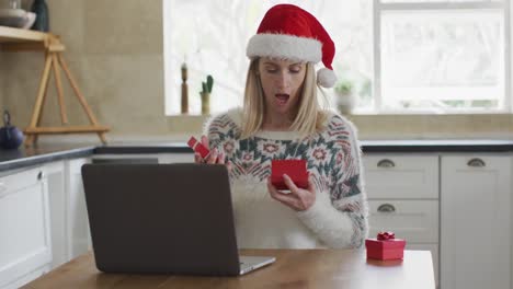 Frau-öffnet-Geschenkbox,-Während-Sie-Einen-Videoanruf-Auf-Dem-Laptop-Führt