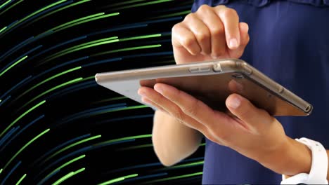 Mid-section-of-woman-using-digital-tablet-against-light-trails-moving-on-black-background