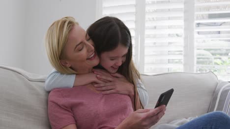 Girl-hugging-her-mother-from-behind-at-home
