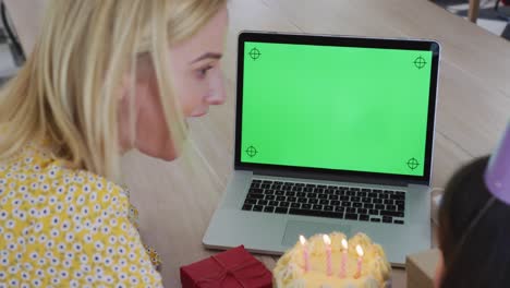 Girl-blowing-cake-while-having-a-video-chat-on-laptop-at-home