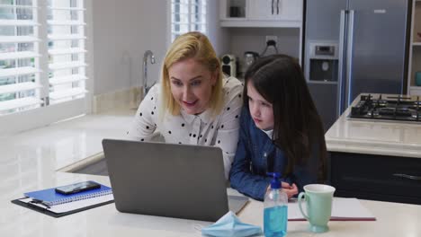 Mother-and-daughter-using-laptop-at-home