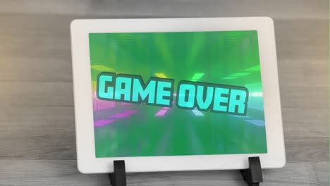 Digital-animation-of-game-over-text-against-glowing-tunnel-on-screen-of-digital-tablet-on-wooden-sur