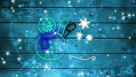 Snowflakes-falling-over-neon-snowman-against-blue-wooden-background