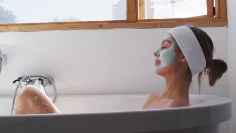 Frau-Mit-Gesichtsmaske-Entspannt-In-Der-Badewanne