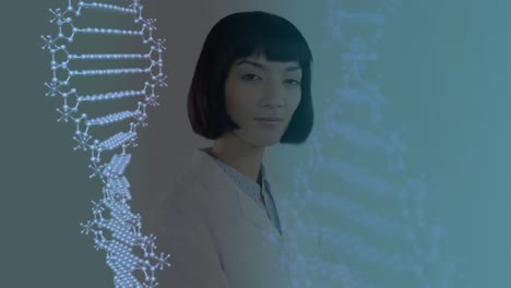 Two-dna-structures-spinning-against-portrait-of-female-doctor-smiling-and-crossing-her-arms-against-