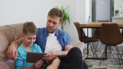 Kaukasischer-Mann-Und-Sein-Sohn-Benutzen-Ein-Digitales-Tablet-Und-Lachen