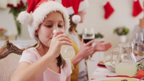 Kaukasisches-Mädchen-Mit-Weihnachtsmütze,-Das-Saft-Trinkt