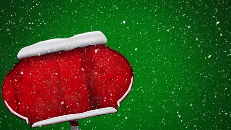 Digital-animation-of-snow-falling-over-red-wooden-sign-post-against-green-background