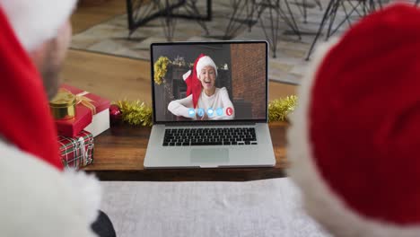 Caucasian-couple-having-a-christmas-video-call-with-family