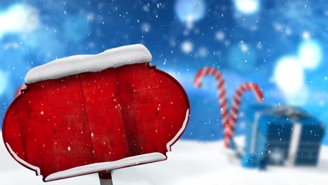 Digitale-Animation-Von-Schnee,-Der-über-Einen-Roten-Wegweiser-Gegen-Eine-Weihnachtsgeschenkbox-Und-Eine-Zuckerstange-Fällt