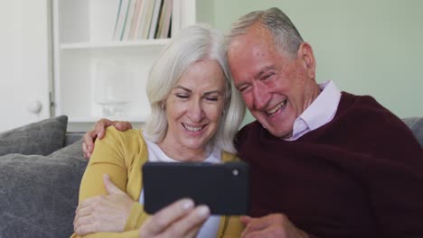 Happy-senior-caucasian-couple-making-video-call-using-laptop-computer