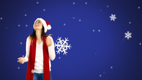 Animación-Digital-De-Copos-De-Nieve-Cayendo-Sobre-El-Retrato-De-Una-Mujer-Con-Sombrero-De-Papá-Noel-Sobre-Fondo-Azul.