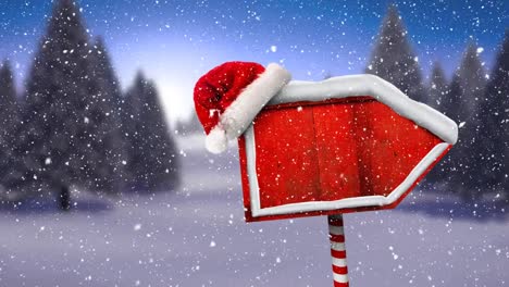 Digital-animation-of-snow-falling-over-santa-hat-on-red-wooden-sign-posts-against-winter-landscape