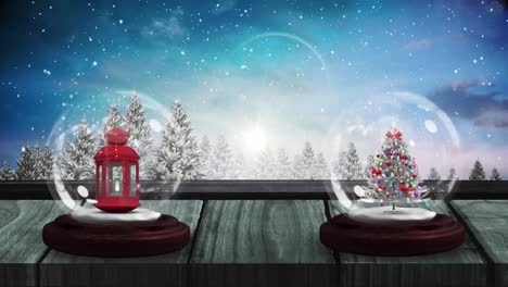 Animation-of-two-snow-globes-with-lantern-and-christmas-tree-on-wooden-surface-and-winter-scenery