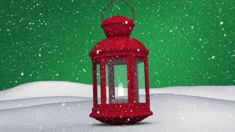 Digital-animation-of-snow-falling-over-christmas-lantern-on-snow-against-green-background